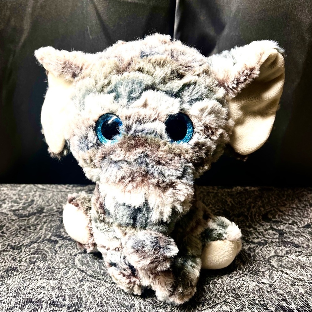 8" Multicolored elephant plushie with blue eyes.